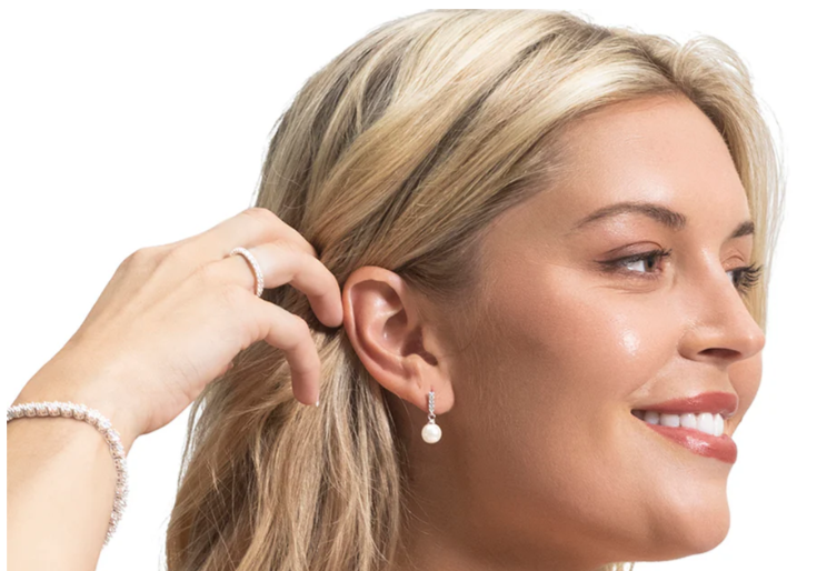 A woman wearing pearl earrings